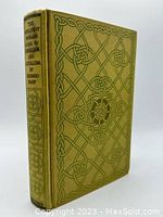 Front cover of vintage hardcover book with ornate geometric and floral design in olive green hues.