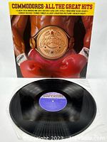 Album cover front with boxer wearing red gloves and championship belt, vinyl record in front.