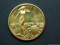 Obverse side of the zodiac coin showing Cancer sign design, birth dates June 22 - July 23, and artistic relief of female figure and crab.