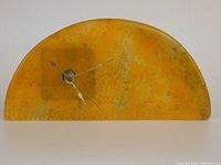 Front view of the yellow-orange half-moon art glass clock showing clock hands and mottled color.