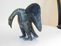 Front/side view of carved bird sculpture showing head, extended wing and body