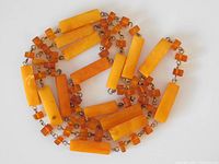 Close-up of amber beads showing the rectangular and smaller rounded shapes and metal connectors.