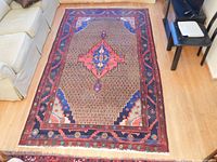 Overhead full view of rug laid on hardwood floor alongside sofa and chairs