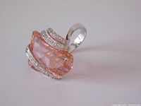 Close-up of a large faceted pink topaz ring set in 925 sterling silver with clear stone accents.