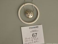 Photo of the handmade 925 sterling silver space motif necklace showing the pendant with multiple holes and the textured bracelet in circular form.