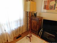 Full view of lamp in room showing scale, tripod base and fabric shade