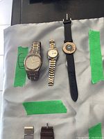 Three Seiko watches arranged side by side on fabric background