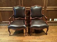 Front view of both chairs against wood-paneled wall