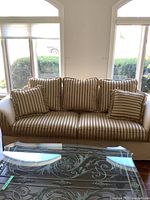 Front view of sofa with striped cushions and fringe-trimmed pillows
