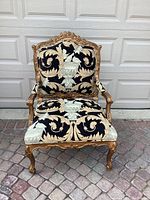 Full front view of the bergere chair showcasing tapestry upholstery and gilt wood frame
