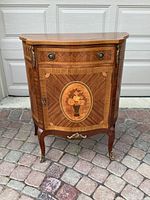 Full front view of end table showing serpentine top and cabinet door with medallion inlay
