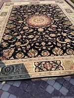 Full view of rug laid flat on brick surface showing overall medallion and border design