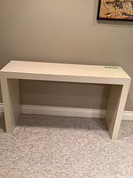 Front view of vintage Parsons console table showing rectangular top and side panels in white finish.