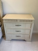 Front view of one night table showing overall appearance, drawer fronts, trim and top surface.