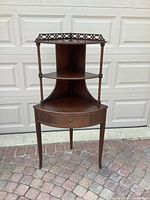 Front view of the vintage corner shelving unit showing three shelves and drawer.