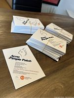 Multiple stacks of 60 packs of Acne Pimple Patch boxes on a table, showing the full lot quantity and packaging style.