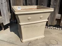 Front angled view of the square ceramic planter showing buttercream glaze with knob detailing and wide rim.