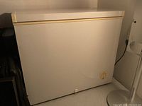 Frigidaire chest freezer full side front view showing beige trim and control knob.