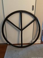 Front view of full circular peace sign leaning against wall
