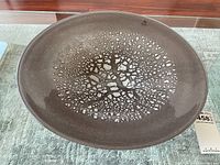 Top view of the large grey art glass bowl showing the full abstract cracked pattern center and the Glass Nuvo Lithuania label near the rim.