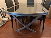 Full view of the dining table set showing chrome trestle base and smoked glass top