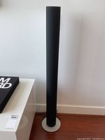 Front view of one speaker on aluminum circular base showing full height and profile