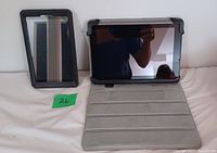 Two Android tablets displayed side-by-side, one Kindle Fire and one Acer, both with protective cases, screens powered off, on a white surface.