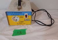 Photo of a rectangular 1 KVA power transformer unit with front panel showing single power outlet, power switch, and attached power cord