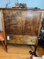 Front view of cabinet showing two doors and lower drawer closed