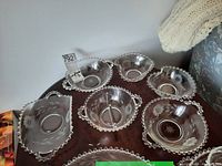 Overview of all six glass serving bowls arranged on a wooden surface, showing etched cornflower floral design and beaded edge detail.