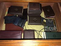 Full drawer view showing multiple wallets and brooches arranged together