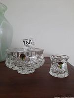 Two Waterford crystal bowls displayed on wooden surface, showing size and shape comparison.