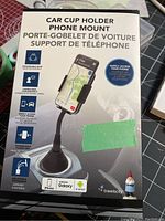 Front box packaging showing car cup holder phone mount, with product features and compatible phone logos.