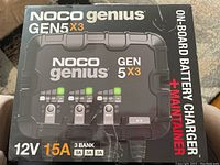Front of NOCO Genius GEN5X3 box showing model name and 12V 15A 3-bank specs