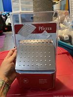 Photo of new Pfister shower head in packaging showing front with logo and visible nozzles