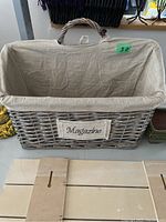 Wicker magazine basket holder with beige fabric liner, handle, and 'Magazine' label on front