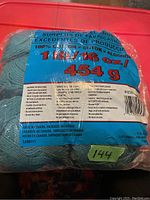 Photo of blue label on yarn packaging showing 16 oz (454 g) weight, 100% cotton, made in Canada.