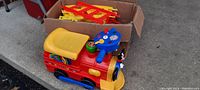 Mickey Mouse kids ride-on train engine with yellow seat and blue steering handle, red body, and Mickey Mouse decal on front.