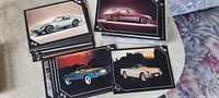 Photo showing multiple Corvette recognition trading cards with various models and colors, spread out on a surface.