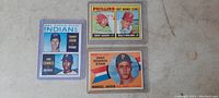 Front of three vintage 1960s baseball cards in protective sleeves, showing portraits and team logos.