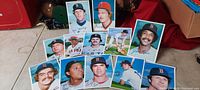 Top-down view of all 12 Boston Red Sox 1981 baseball photo cards arranged on a flat surface with red background, showing front image portraits of the players.
