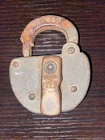 Front view of antique B&O railroad padlock showing locking lever and surface rust