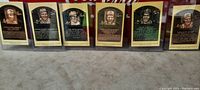 Six embossed bronze plaque collector cards featuring Baltimore Orioles Hall of Fame players, with player biographies, shown upright in protective cases.