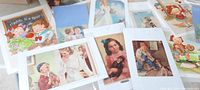 Lot of 14 antique paper prints in protective sleeves spread out, showing various vintage advertising illustrations including children, products, and family scenes.
