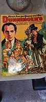 Front cover of the vintage book 'Dunninger's Magic Tricks' showing colorful vintage illustration of a man and a magician with flowers.