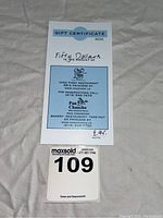 Photo of the $50 gift certificate for Chez Piggy and Pan Chancho along with a MaxSold lot number card.