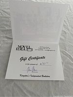 Open card showing the printed gift certificate inside with the amount $30 handwritten and signed.
