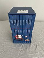 Blue slipcase containing eight hardcover volumes showing spines with composite Tintin and Snowy image and volume numbers