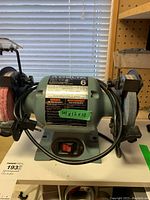 Front view of Delta bench grinder showing both grinding wheels and power switch on the front base.