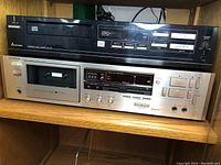 Front view showing Mitsubishi DP-107 CD player above Luxman K-240 cassette deck on wood shelf